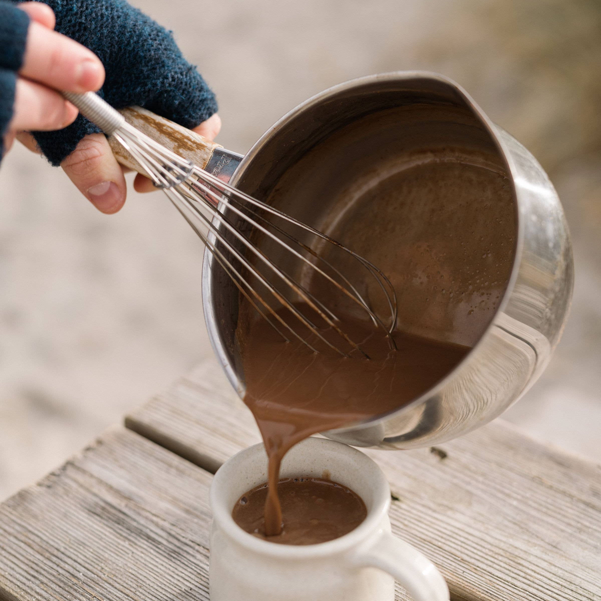 Harth hot chocolate being poured from a saucepan into a mug