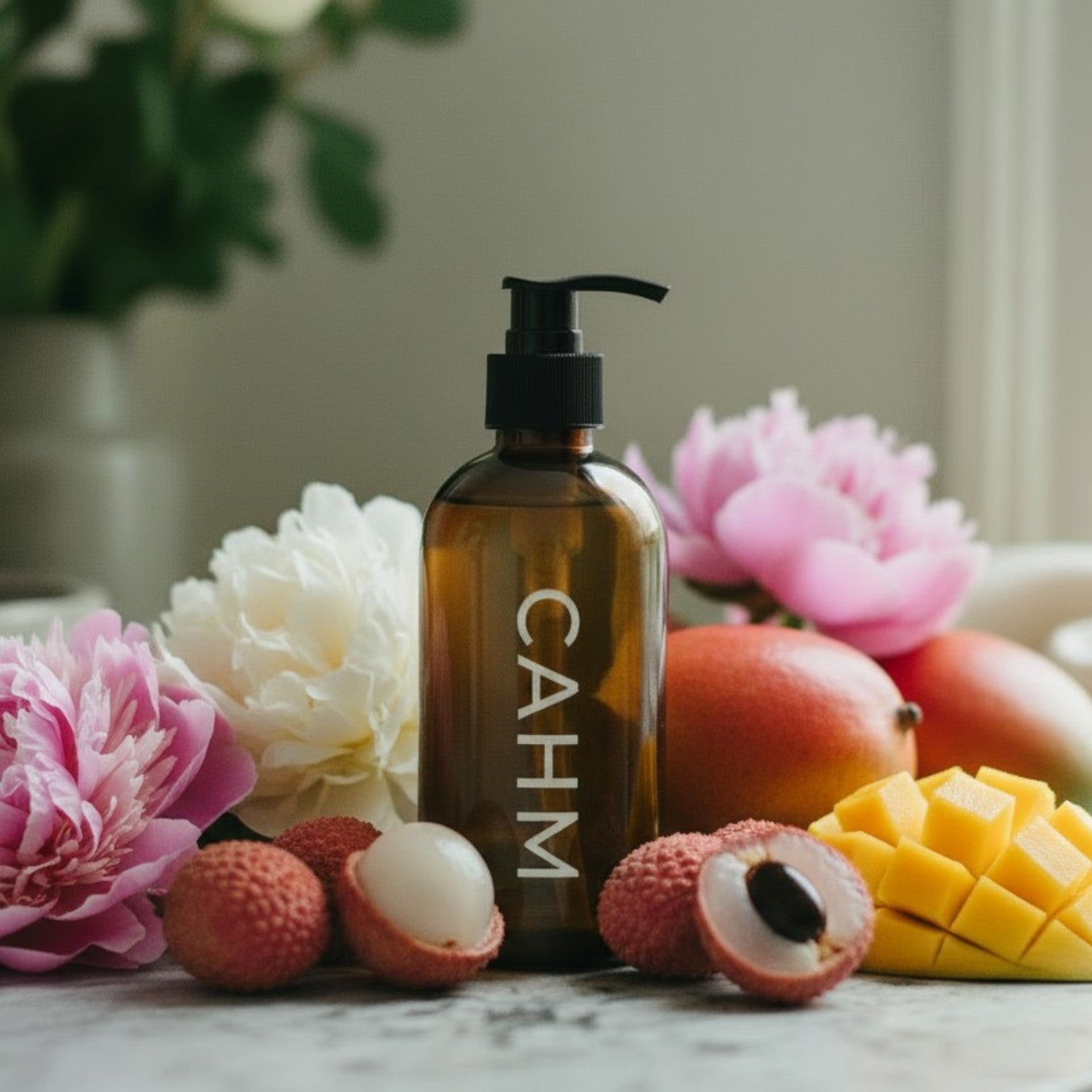 Brown bottle with 'CAHM' branding surrounded by fruits and flowers on a marble surface